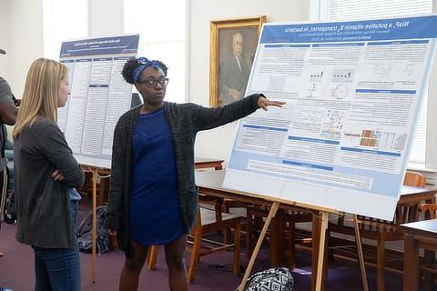 female student explaining her research BC04198219